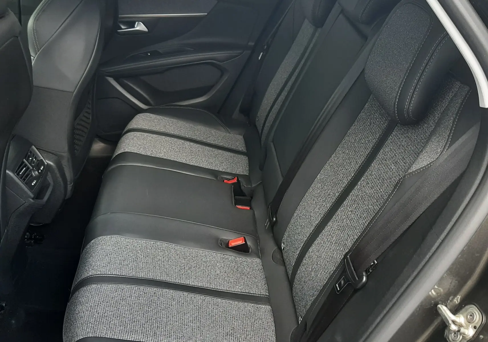 Vue intérieure côté droit des sièges arrière en tissu gris et cuir noir du Peugeot 3008 gris Amazonite de 2019.