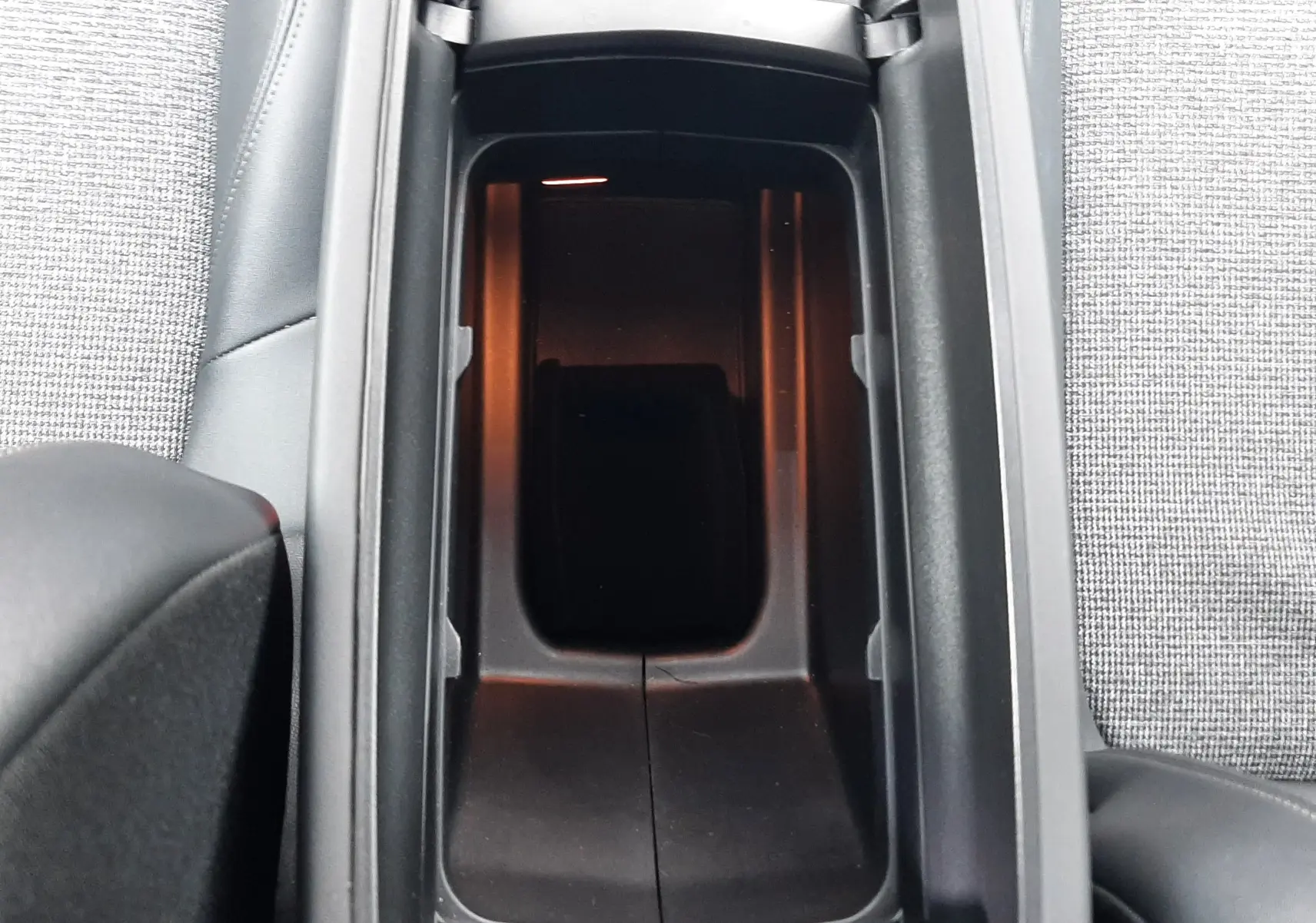 Vue plongeante sur le rangement central noir entre les sièges gris tissu du Peugeot 3008 2019 gris Amazonite.