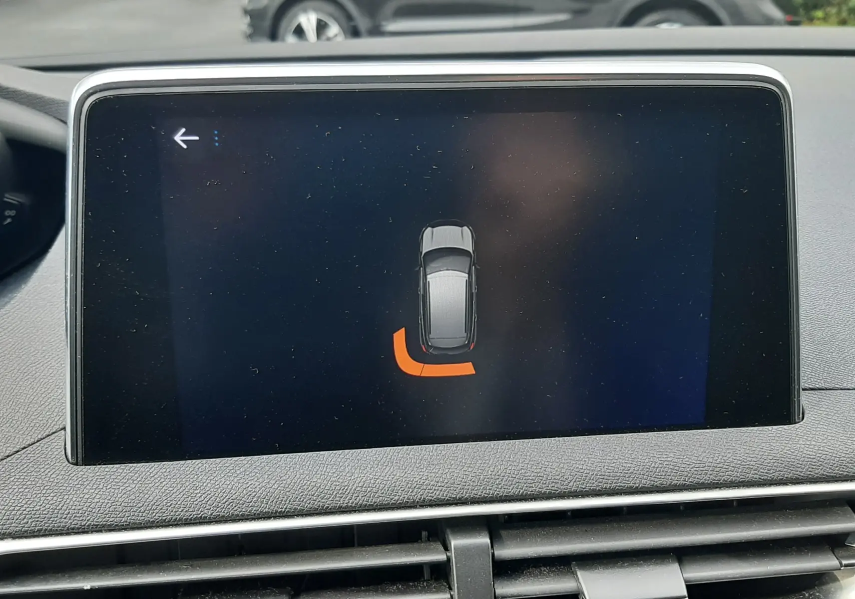 Vue intérieure de l'écran tactile du Peugeot 3008 gris Amazonite, affichant l'alerte de proximité arrière gauche.