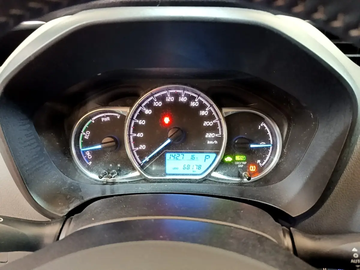Vue rapprochée du tableau de bord de la Toyota Yaris hybride 2019 avec compteur digital et voyants allumés.