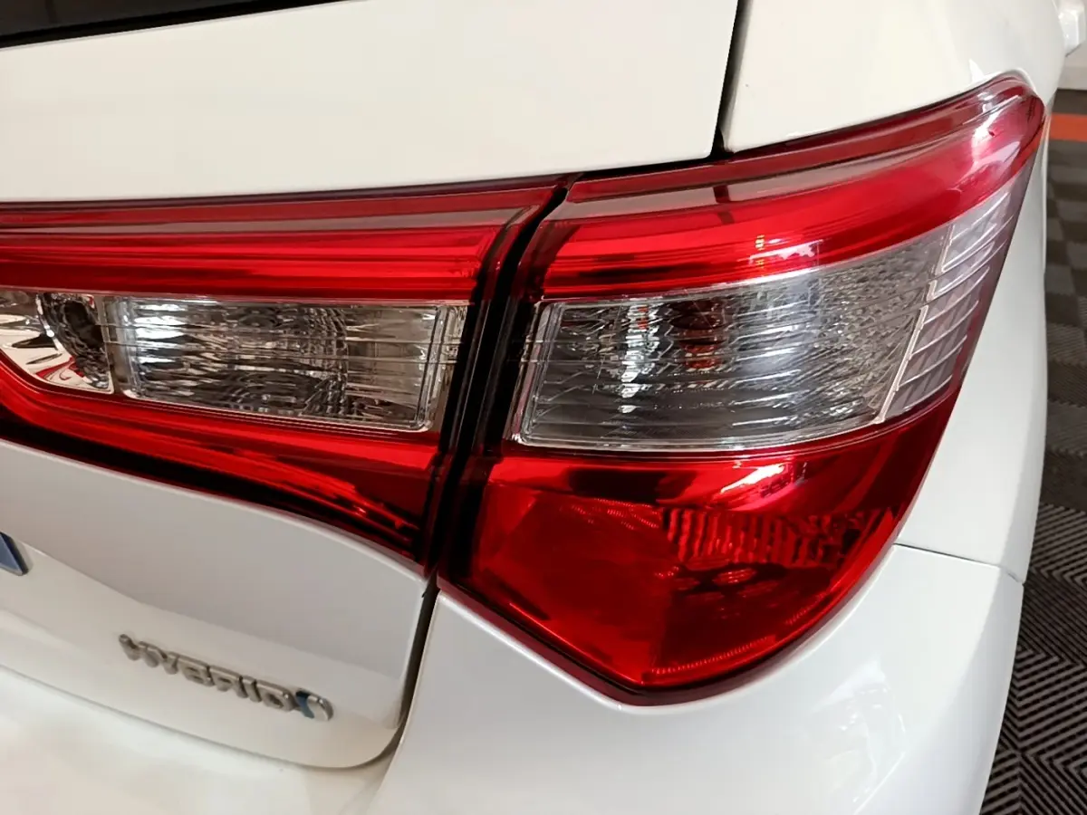 Gros plan sur le feu arrière droit rouge et blanc d’une Toyota Yaris blanche hybride 2019.