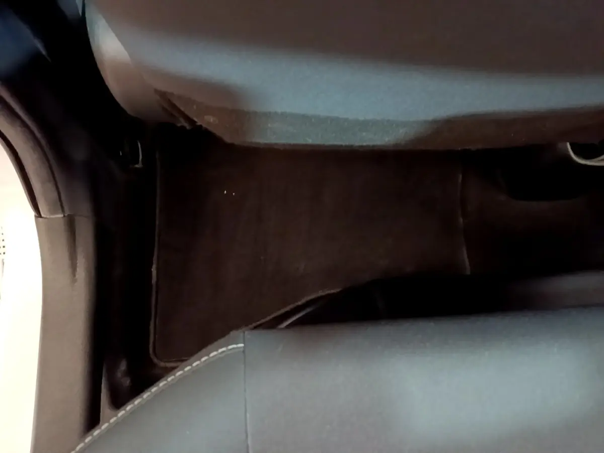Vue rapprochée du plancher et de la base du siège avant droit d’une Toyota Yaris blanche, intérieur sombre.