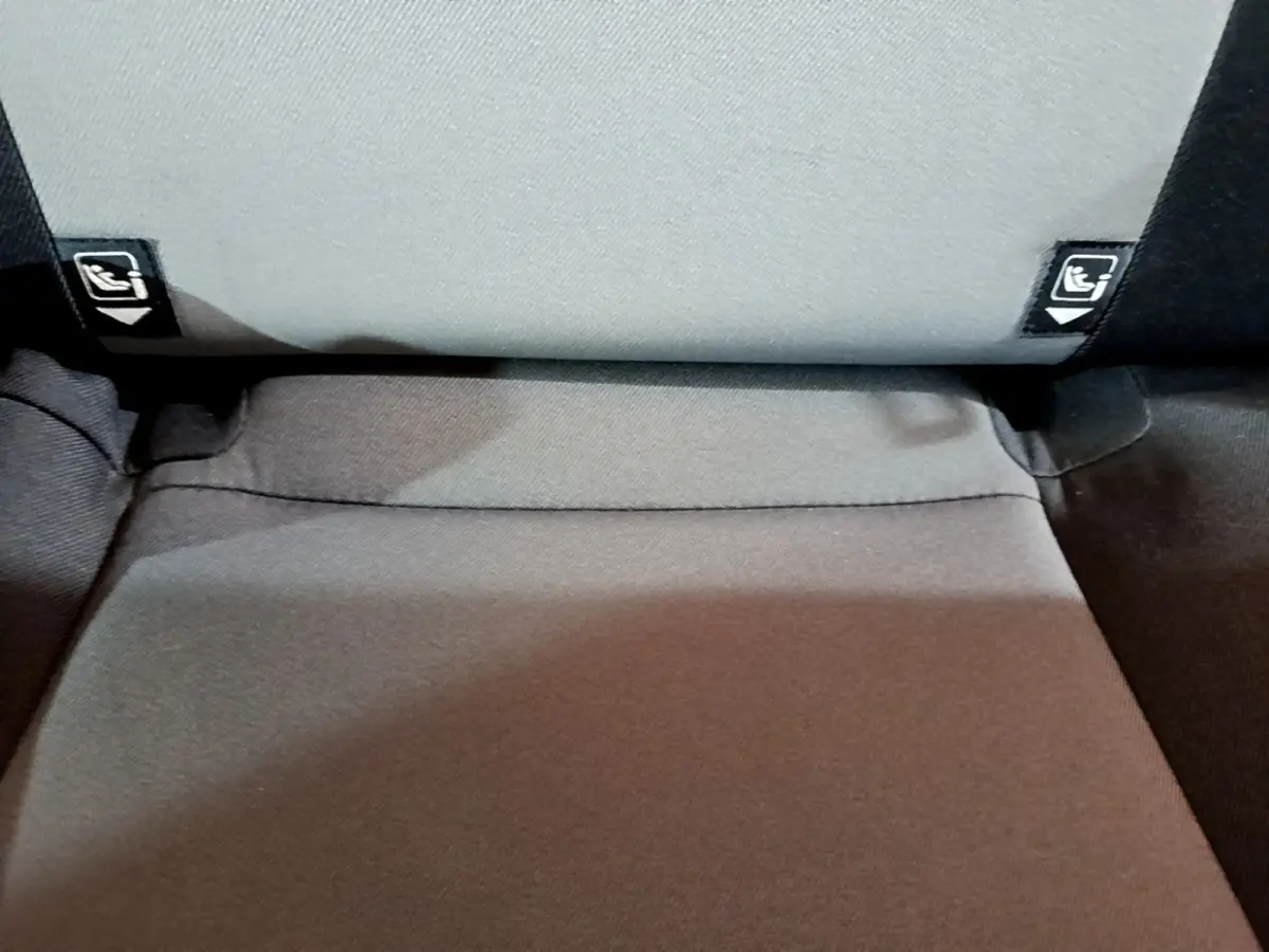 Détail de la banquette arrière grise avec étiquettes Isofix visibles sur une Toyota Yaris blanche hybride 2019.