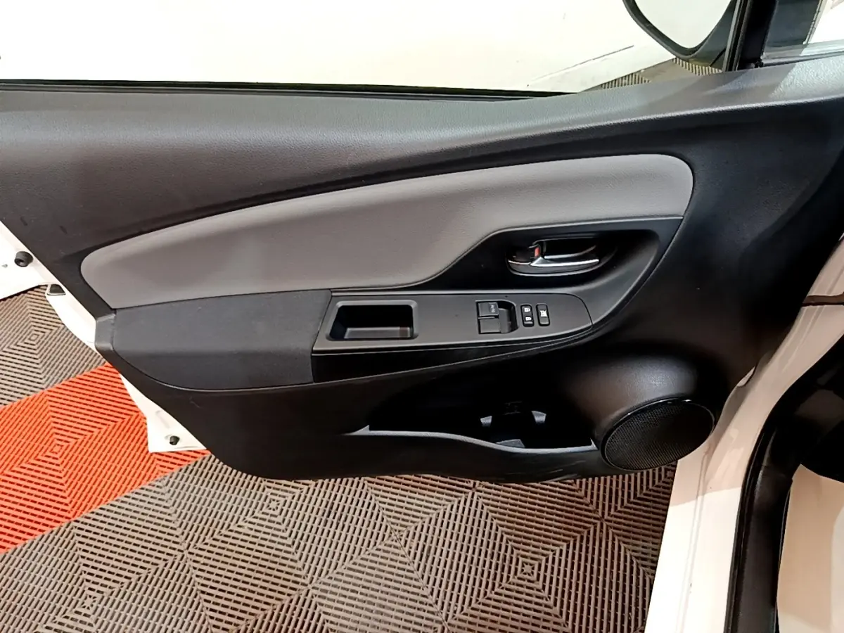 Vue intérieure de la porte avant gauche blanche de la Toyota Yaris 2019, avec commandes électriques et haut-parleur intégré.