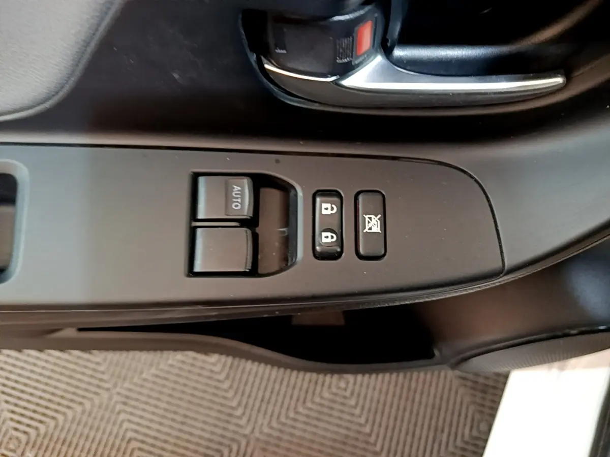 Gros plan sur la commande des vitres et verrouillage côté gauche intérieur d’une Toyota Yaris blanche 2019.