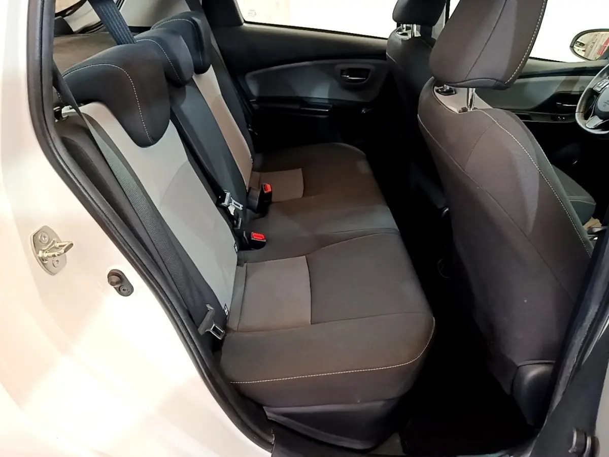 Vue intérieure côté gauche sur la banquette arrière grise et noire de la Toyota Yaris blanche 2019, version hybride.
