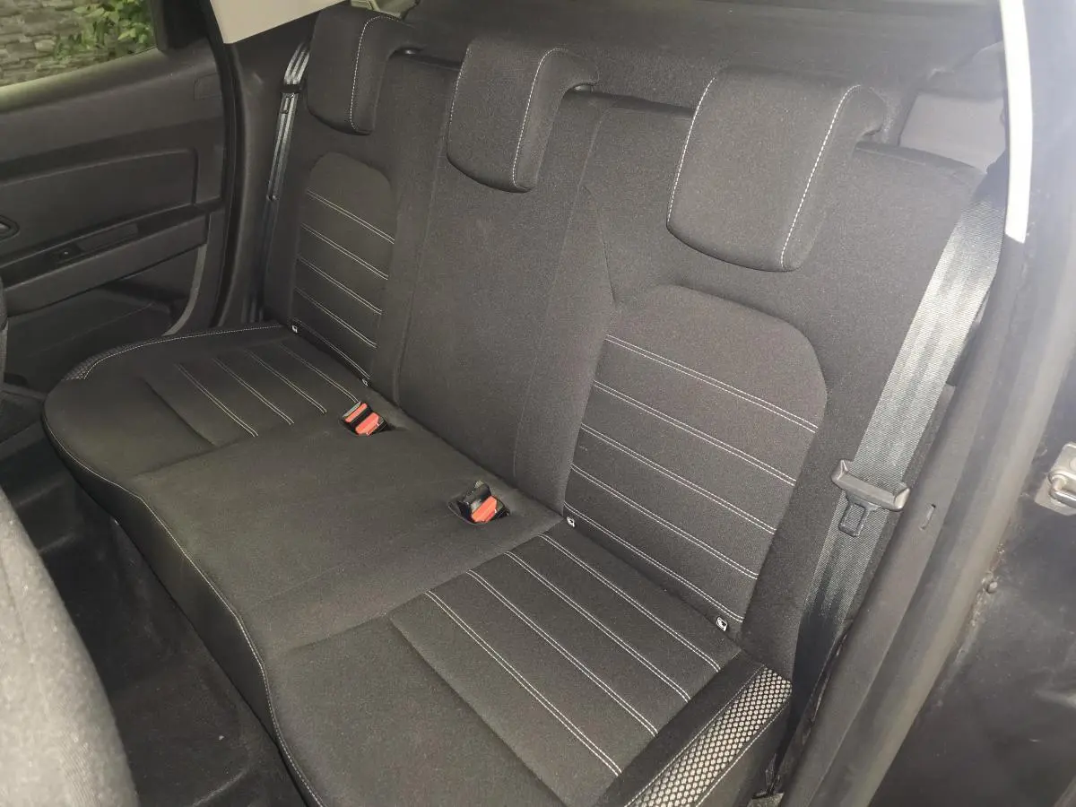Vue intérieure du siège arrière tissu noir avec surpiqûres blanches du Dacia Duster 2019 côté droit ouvert.