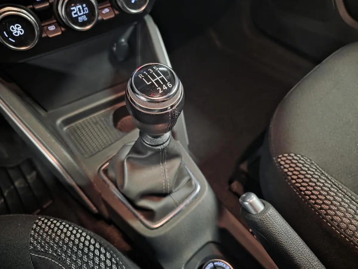 Gros plan sur le levier de vitesses manuel et frein à main du Dacia Duster 1.3 TCe 130 Prestige, intérieur noir.