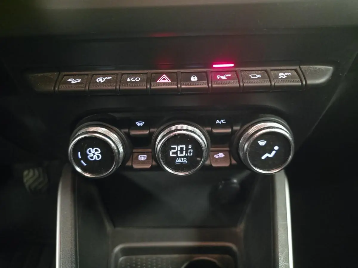 Vue rapprochée des commandes de climatisation automatique du Dacia Duster 2019, avec affichage digital à 20,6°C.