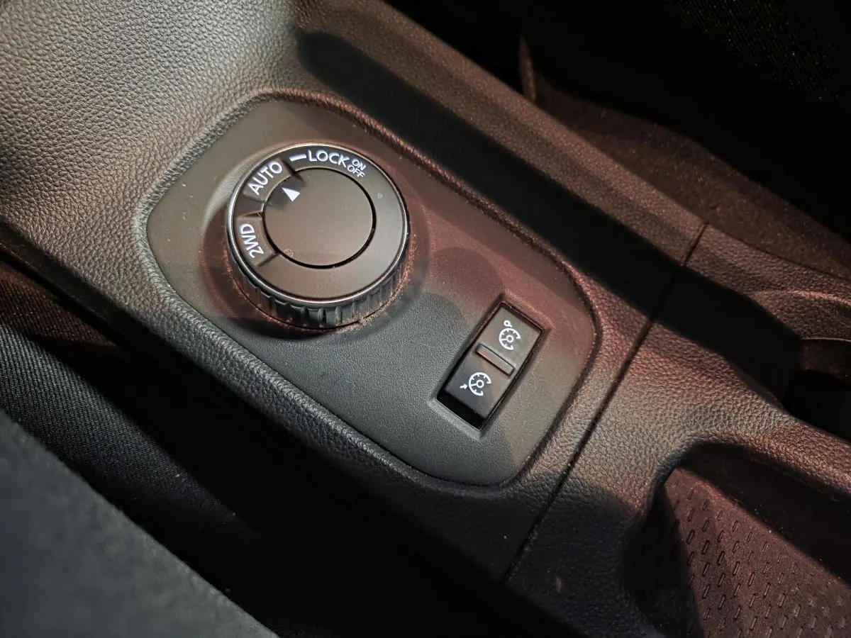 Gros plan sur la molette de sélection 4x4 et les boutons de régulateur de vitesse du Dacia Duster 1.3 TCe noir.