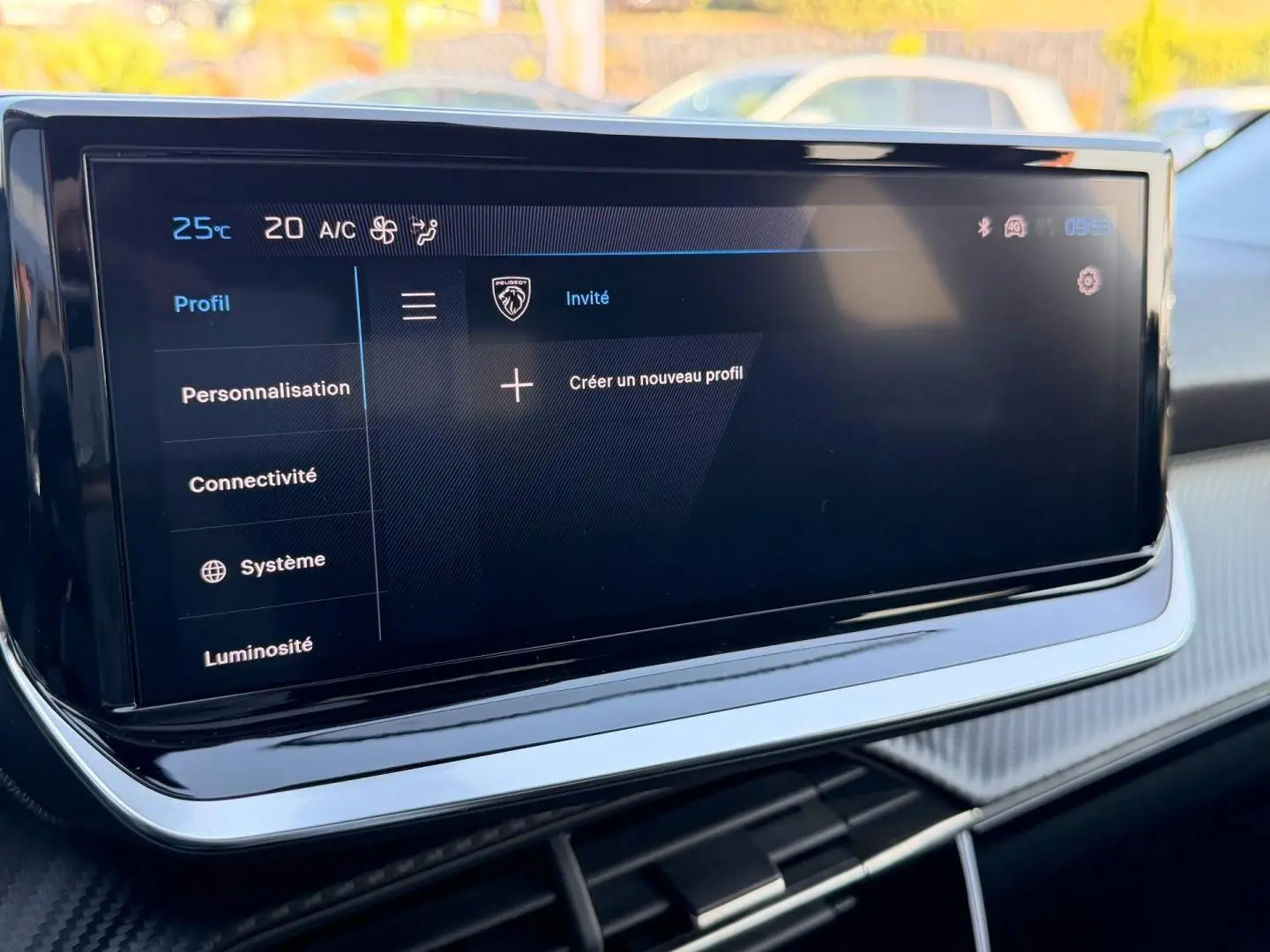Écran tactile multifonction Peugeot 208 2025 en gros plan, affichant le menu profil sur fond noir.