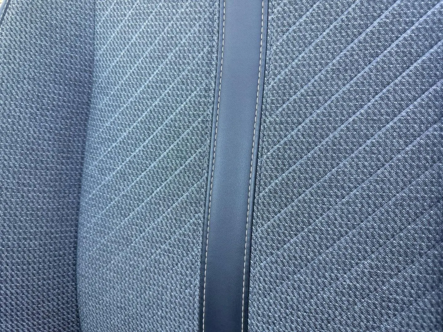 Gros plan sur le tissu gris Casual Lomsa avec bande centrale en simili cuir sur le siège avant d'une Peugeot 208 2025.