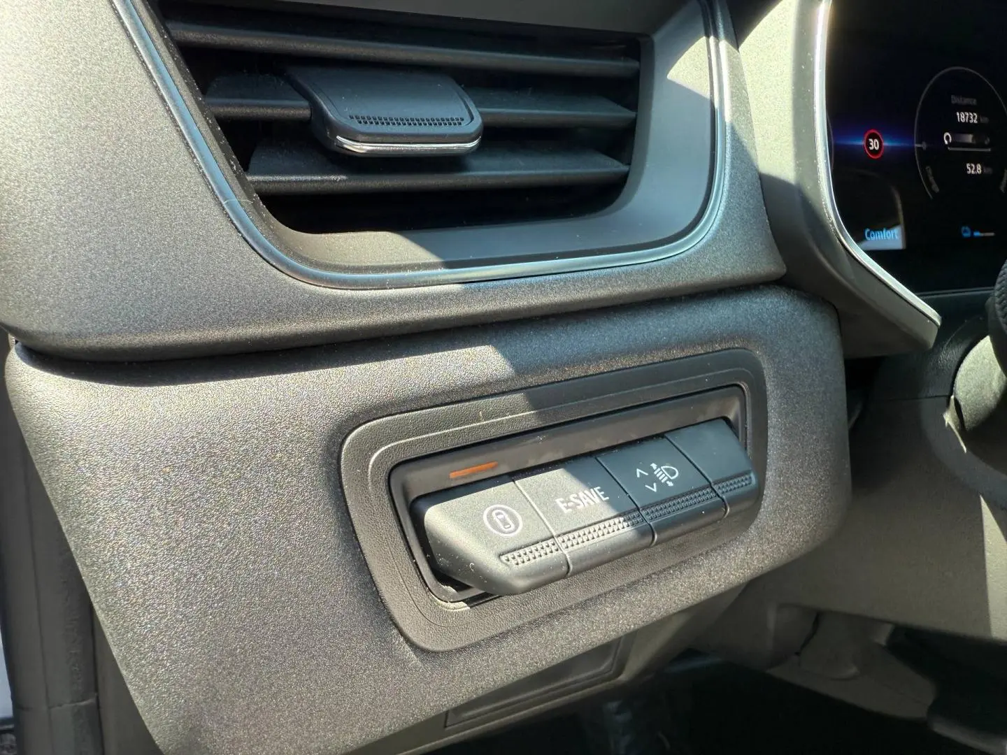 Détail des commandes E-SAVE et réglage des phares sur le tableau de bord gris du Renault Captur 2025.