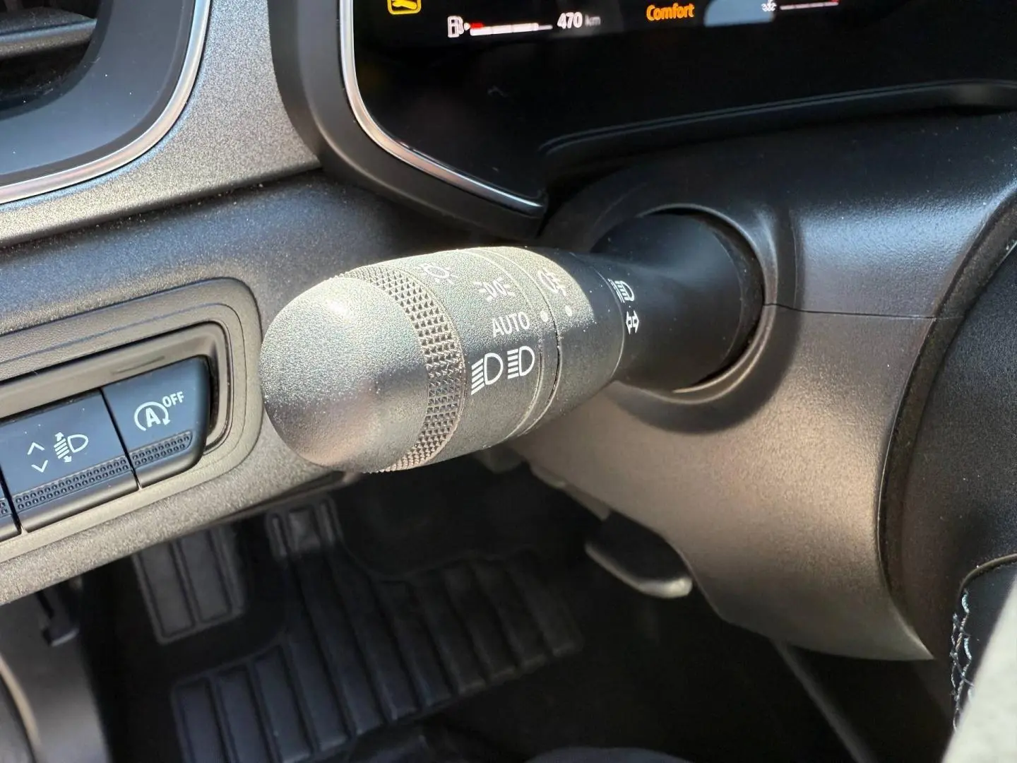 Gros plan sur la commande des phares et essuie-glaces du Renault Captur 2025, intérieur noir avec détails gris.