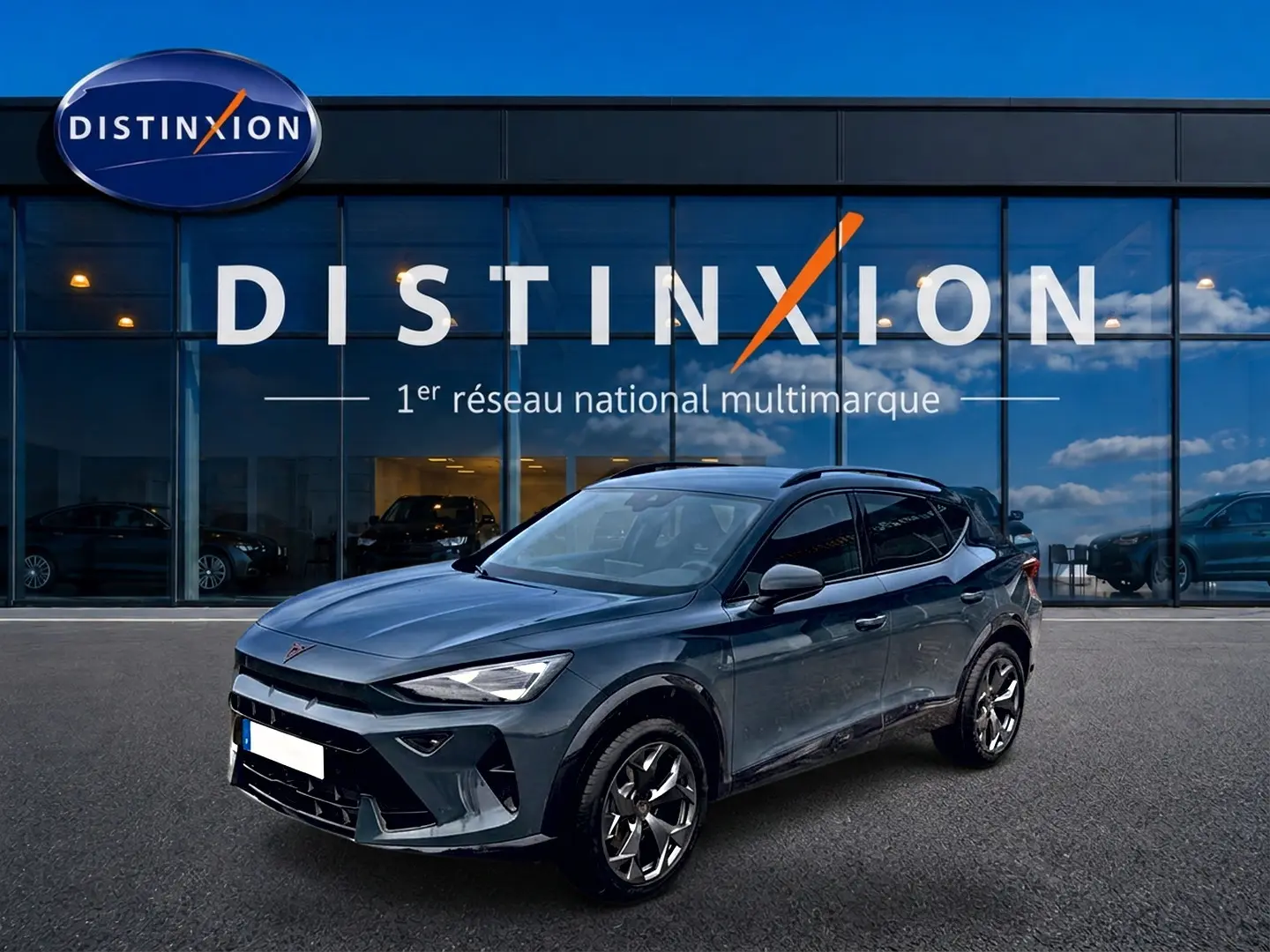 Vue 3/4 avant droite d'un CUPRA Formentor bleu fjord 2026 avec jantes 18 pouces et toit noir devant une vitrine Distinxion.
