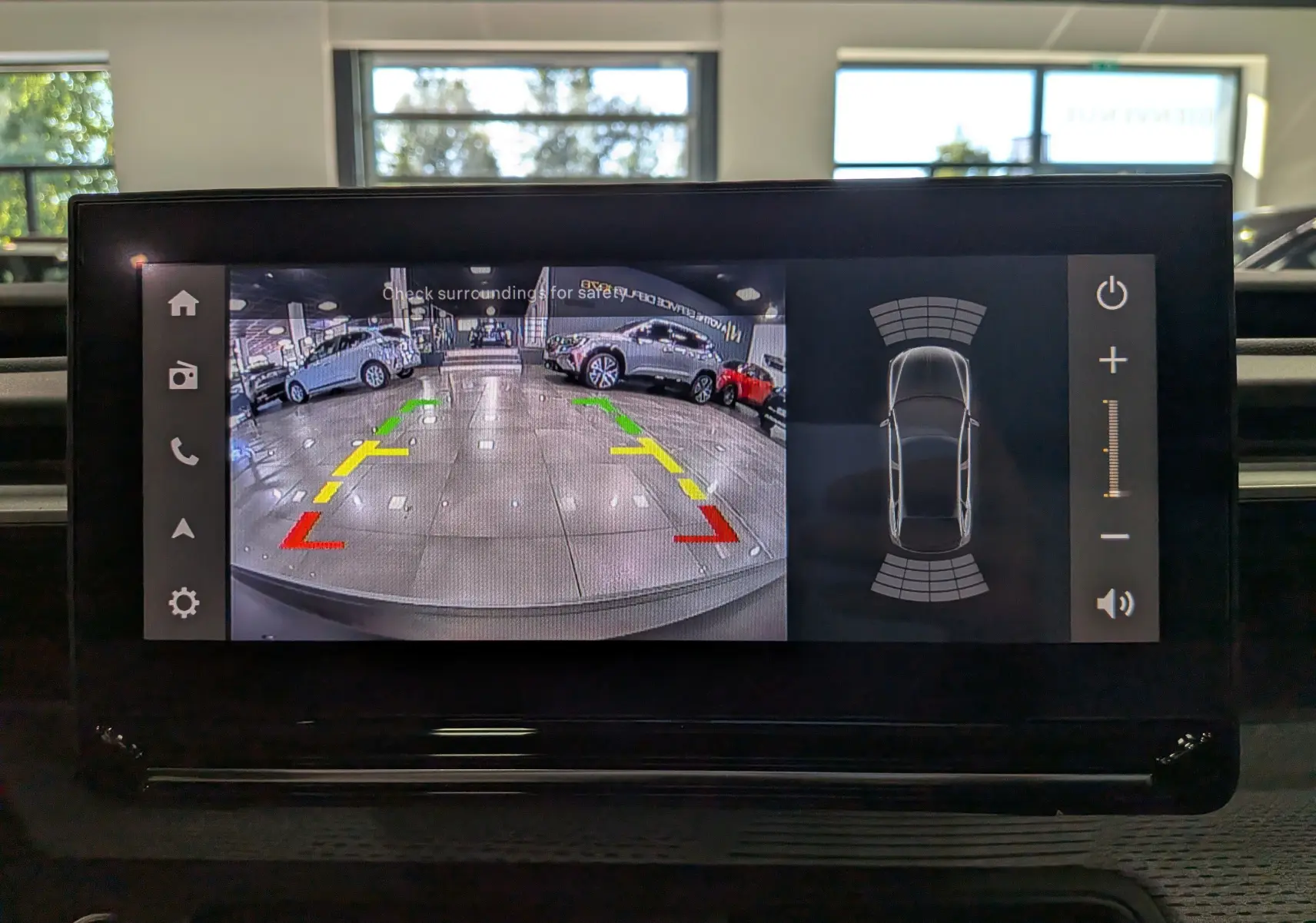 Écran intérieur montrant la caméra de recul et les capteurs de stationnement du Citroën C3 Aircross hybride rouge Elixir toit noir.
