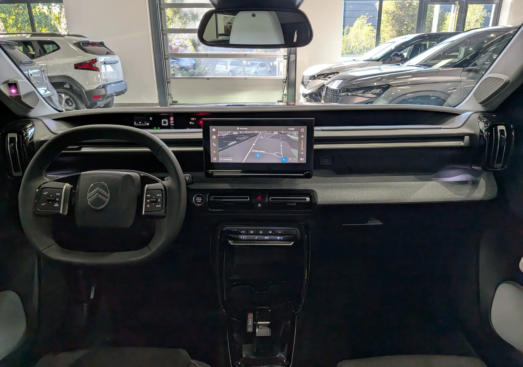 Vue intérieure frontale du tableau de bord de la Citroën C3 Aircross hybride 2026 avec écran tactile et volant multifonction.