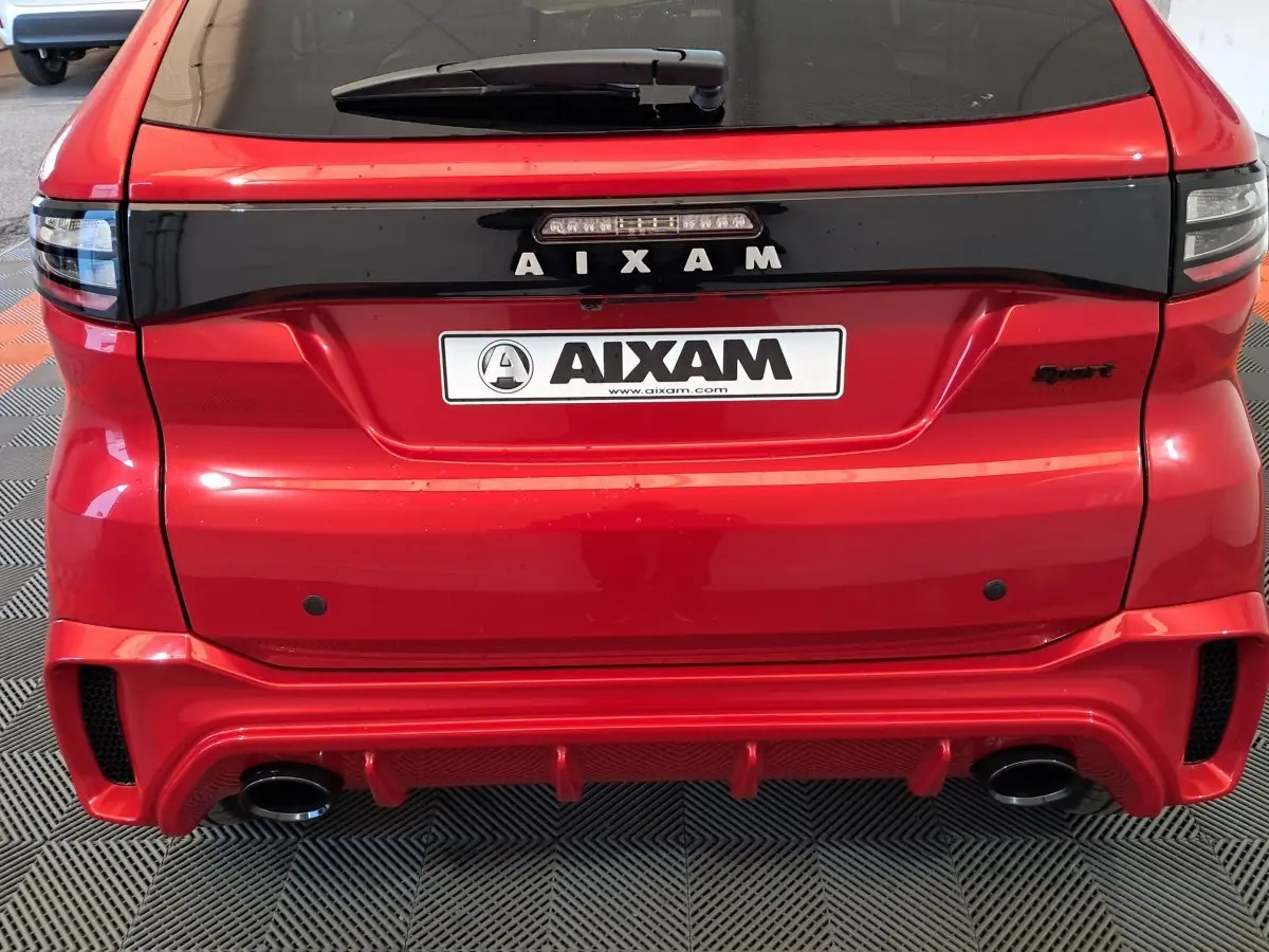 Vue arrière d'une Aixam Ambition rouge 2025 avec logo AIXAM et double sortie d'échappement intégrée au pare-chocs sport.