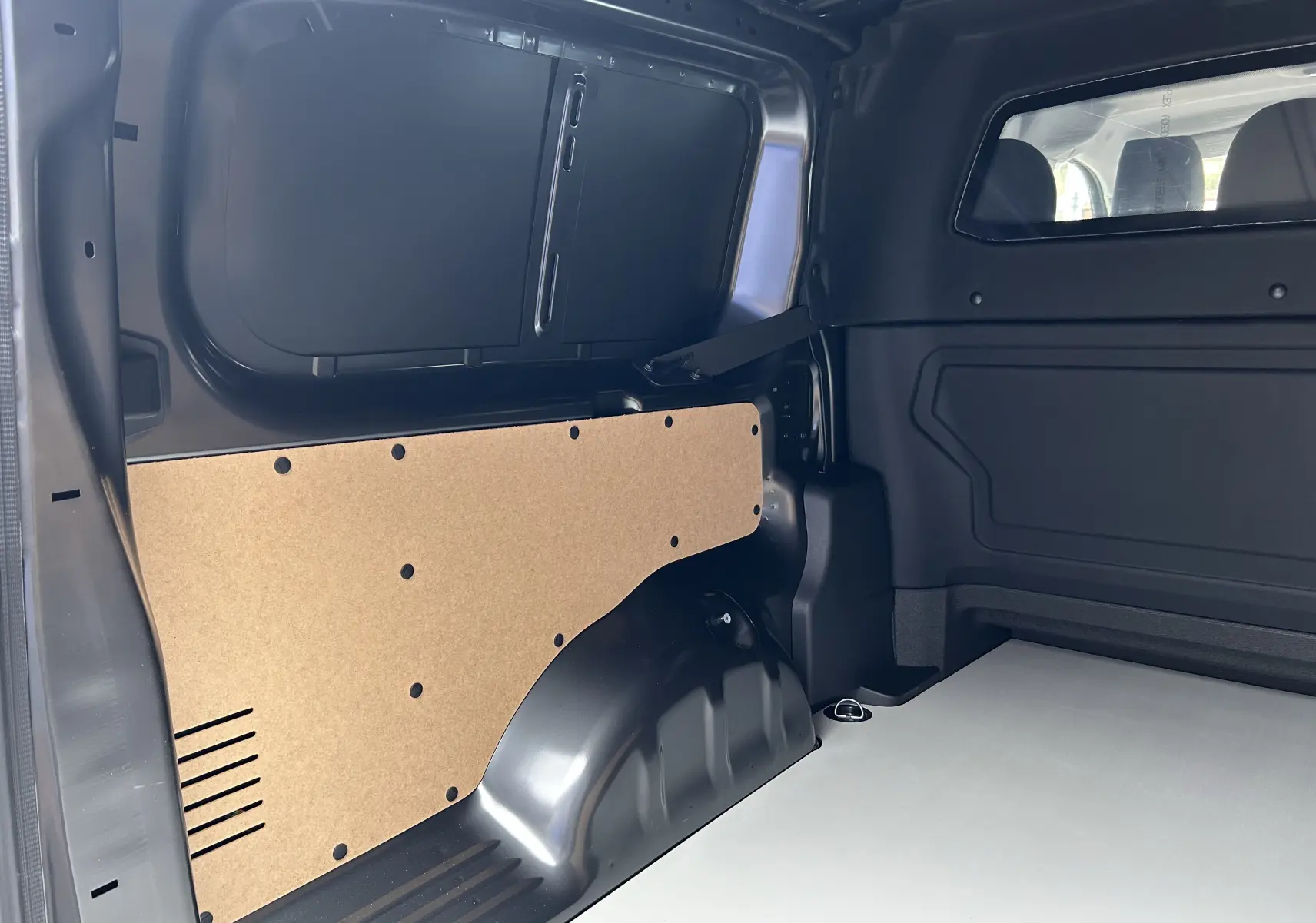 Vue intérieure arrière droite du Citroën Jumpy Cabine Approfondie gris titane, montrant la cloison et le plancher utilitaire.