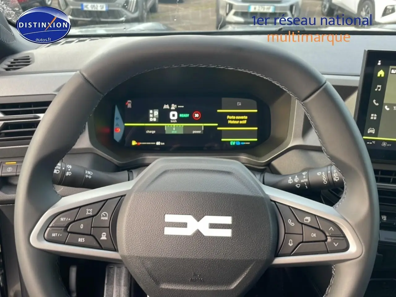 Vue centrée sur le volant cuir noir et tableau de bord numérique du Dacia Bigster gris schiste 2025 hybride.