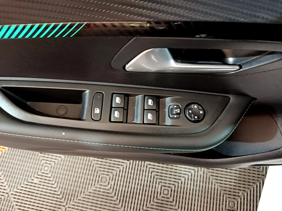 Gros plan sur la commande des lève-vitres et rétroviseurs côté gauche intérieur de la Peugeot 208 blanche 2021.