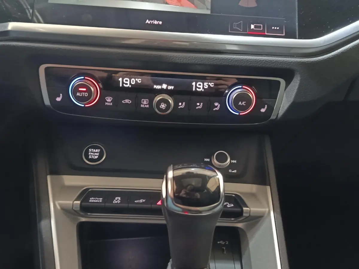 Gros plan sur la console centrale de l'Audi Q3 Sportback 45 TFSI e, montrant la commande de climatisation digitale et le levier de vitesse.