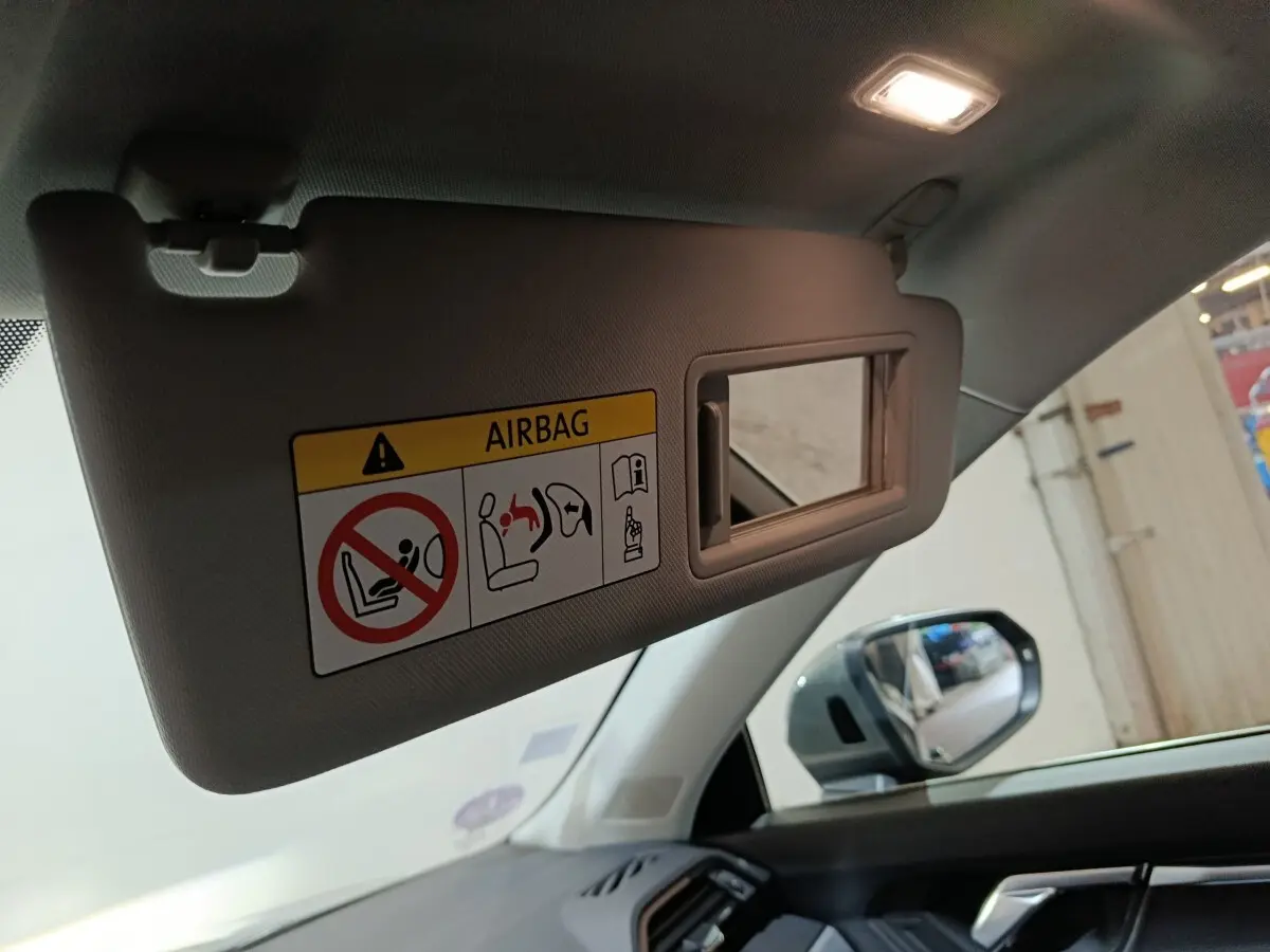 Pare-soleil côté conducteur avec miroir intégré et avertissement airbag dans l'Audi Q3 Sportback gris foncé, vue intérieure avant droite.