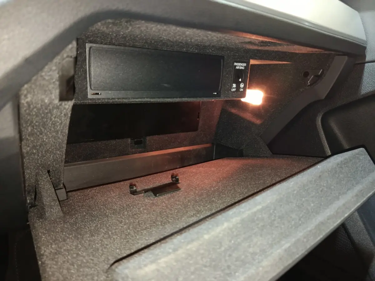 Intérieur de la boîte à gants ouverte de l'Audi Q3 Sportback gris foncé, avec éclairage intérieur activé.