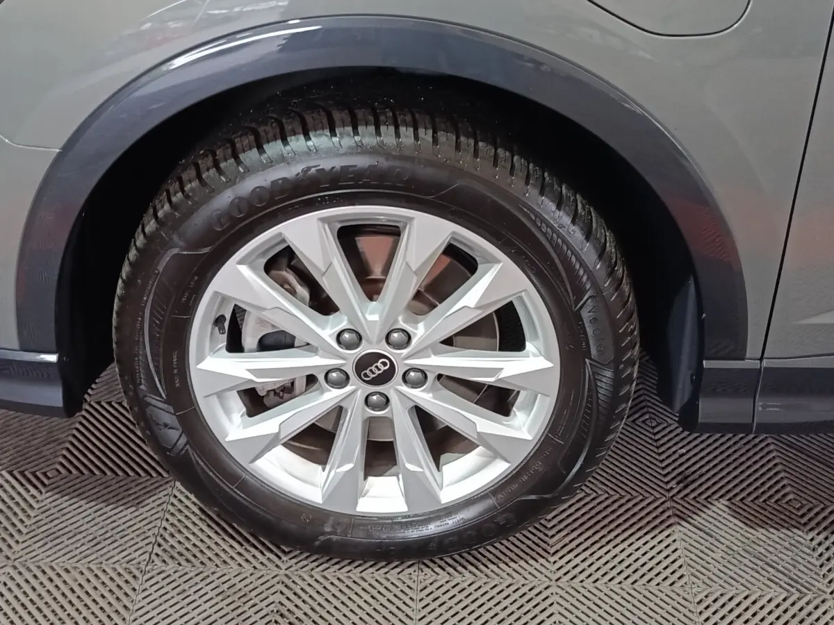 Gros plan sur la roue avant droite gris foncé d’un Audi Q3 Sportback 45 TFSI e avec jante argentée à dix branches.