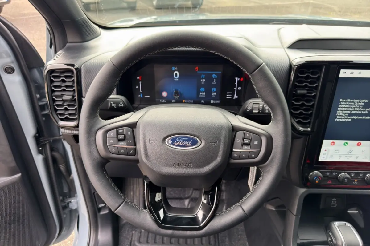 Vue centrée sur le volant cuir multifonctions et tableau de bord numérique du Ford Ranger gris commandeur 2026.