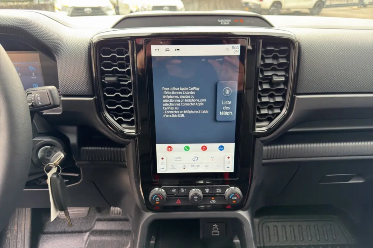 Vue rapprochée du tableau de bord du Ford Ranger 2026, avec écran tactile vertical et commandes climatisation visibles.