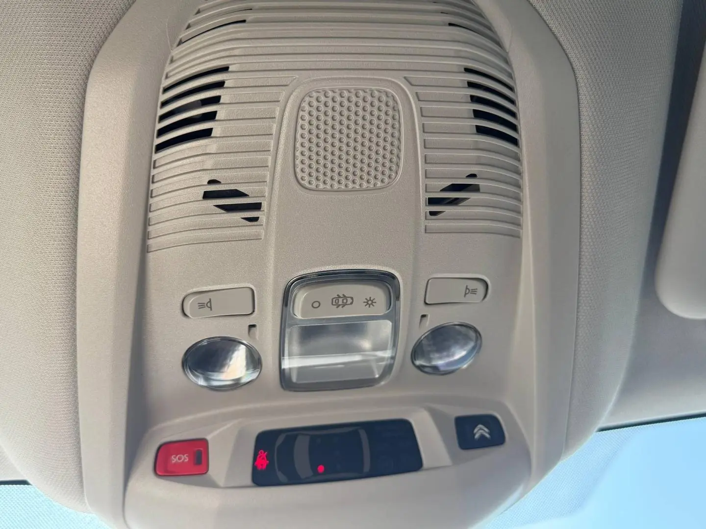 Vue intérieure du plafonnier gris clair avec commandes d’éclairage et bouton SOS du Citroën C5 Aircross blanc.