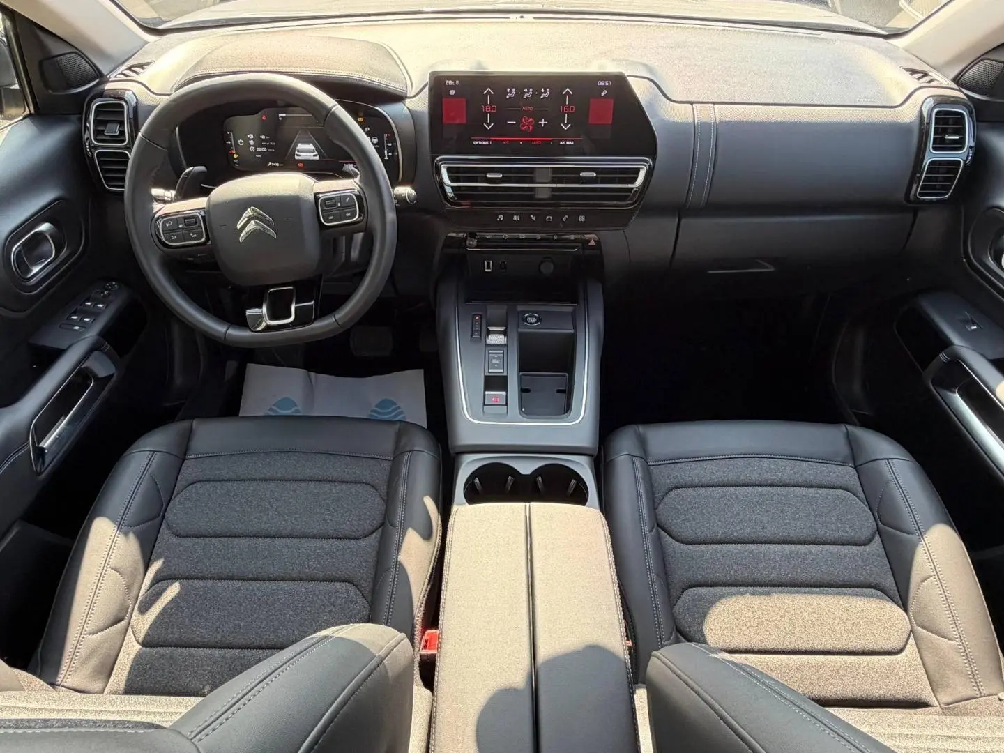Vue intérieure avant du Citroën C5 Aircross 2025, tableau de bord et volant cuir multifonction noir.
