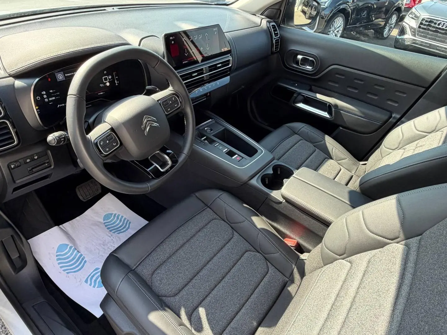 Vue intérieure côté conducteur du Citroën C5 Aircross 2025, avec sièges tissu noir et tableau de bord moderne.