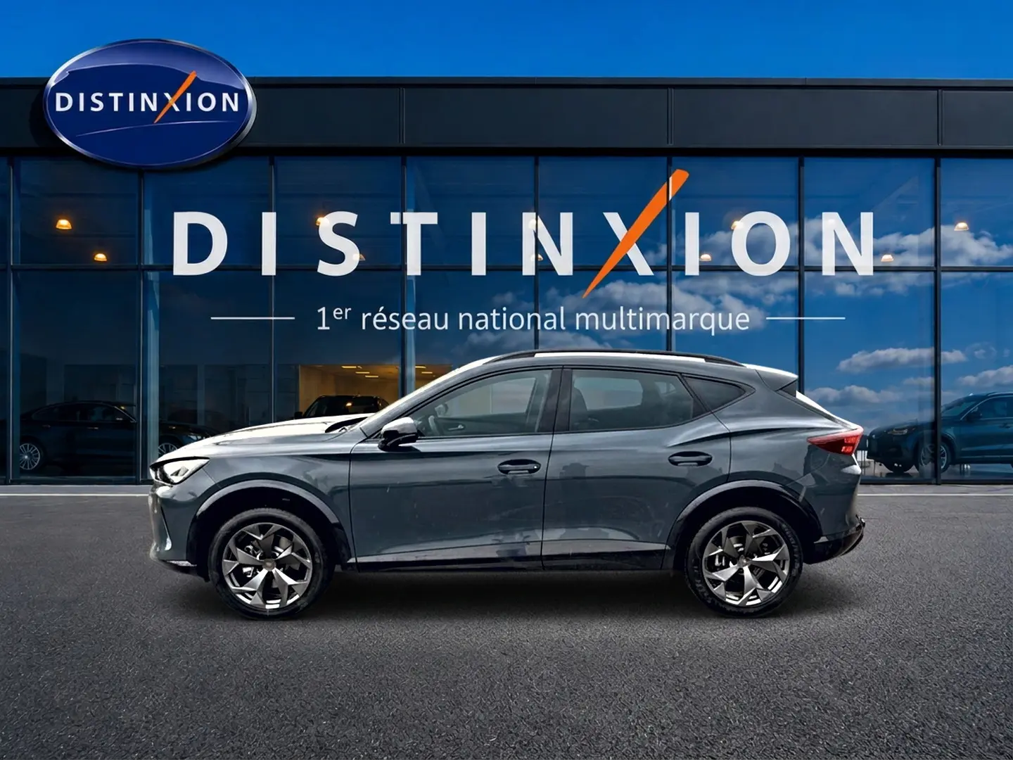 Profil côté gauche d'un CUPRA Formentor bleu fjord 2026 garé devant une vitrine avec logo Distinxion.