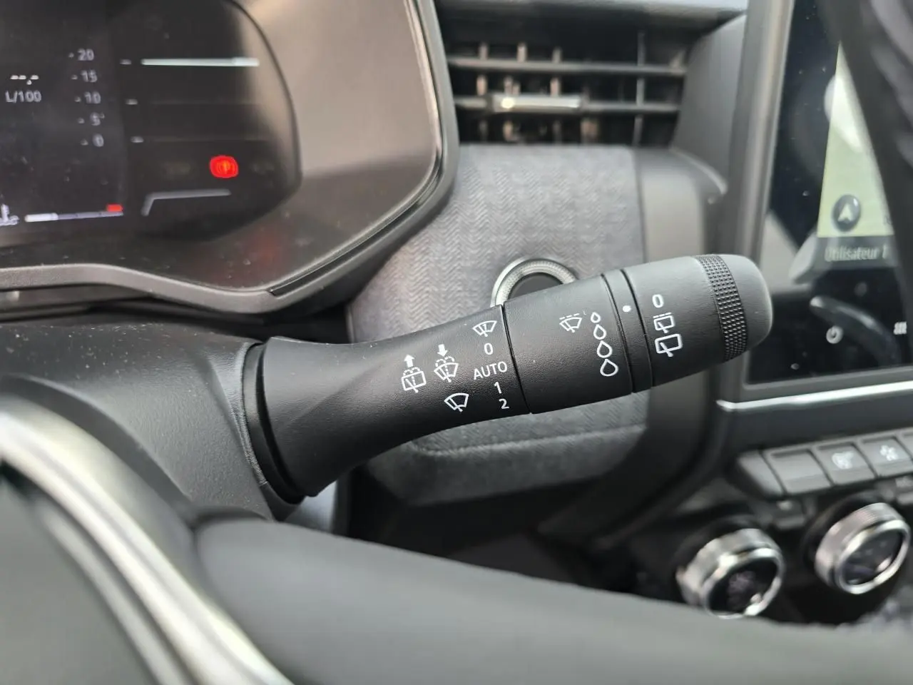 Gros plan sur la commande des essuie-glaces à gauche du volant dans l’habitacle gris mélangé de la Renault Clio V 2025.