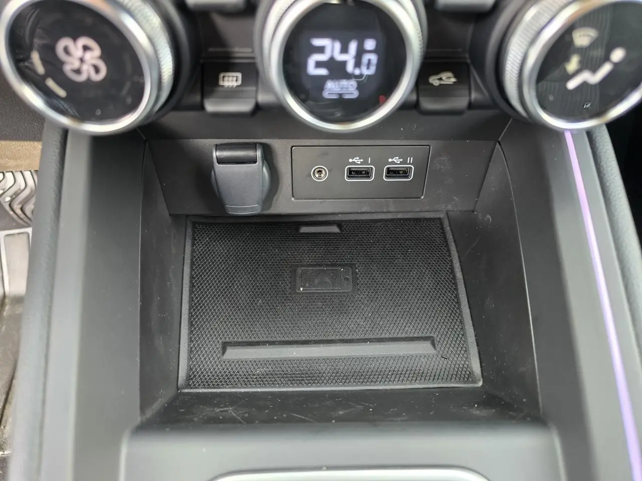 Vue rapprochée de la console centrale de la Renault Clio 2025, avec commandes climatisation et ports USB visibles.