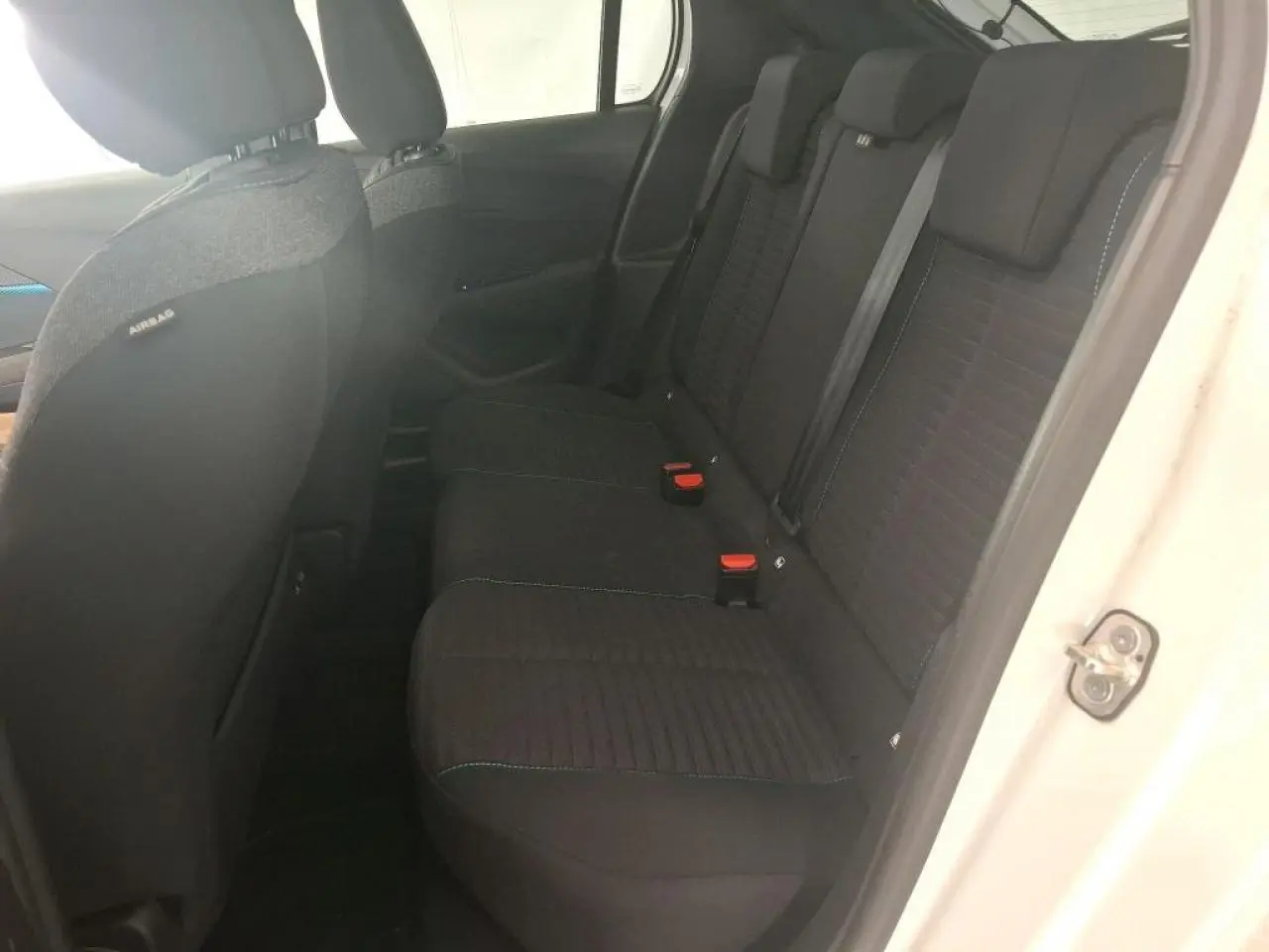 Vue intérieure côté droit sur la banquette arrière noire avec ceinture de sécurité d'une Peugeot 208 blanche 2022.