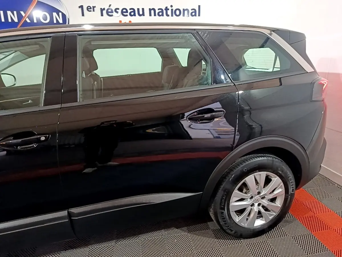 Vue latérale droite du Peugeot 5008 noir, mettant en valeur les vitres teintées et les jantes alliage.