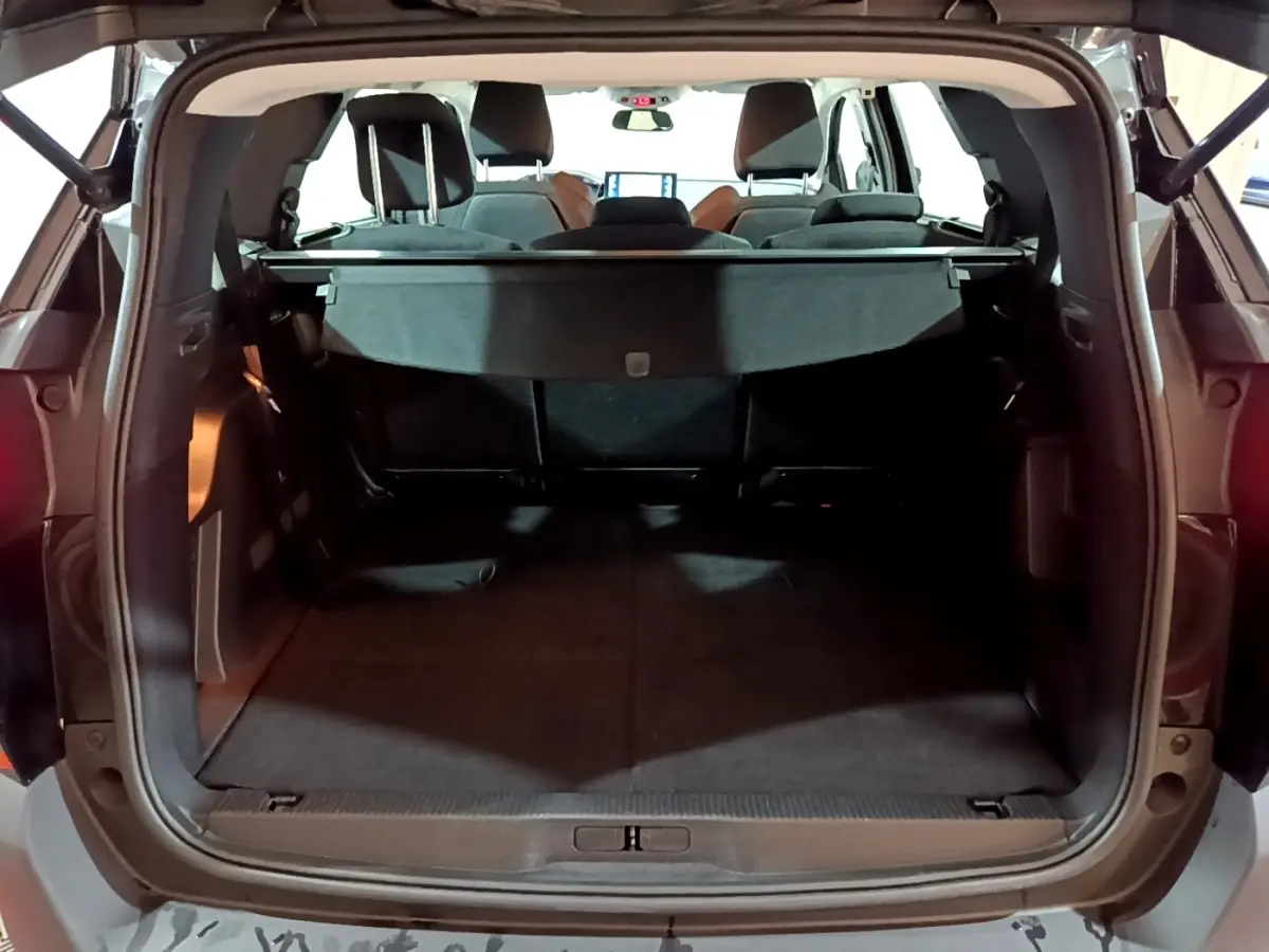 Vue arrière du coffre ouvert du Peugeot 5008 noir, montrant l'espace de chargement et la tablette cache-bagages.