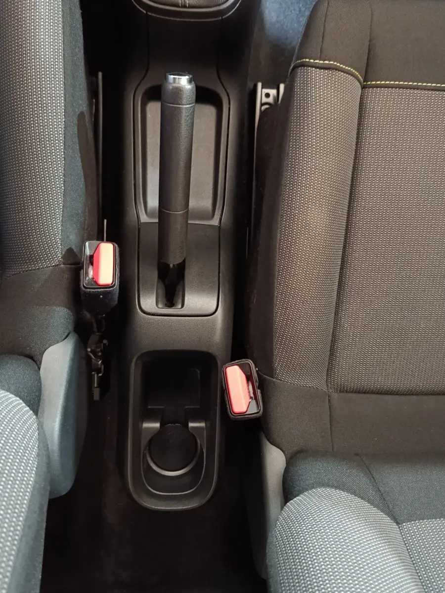 Vue plongeante sur la console centrale noire avec frein à main manuel et sièges tissu gris de la Citroën C3.