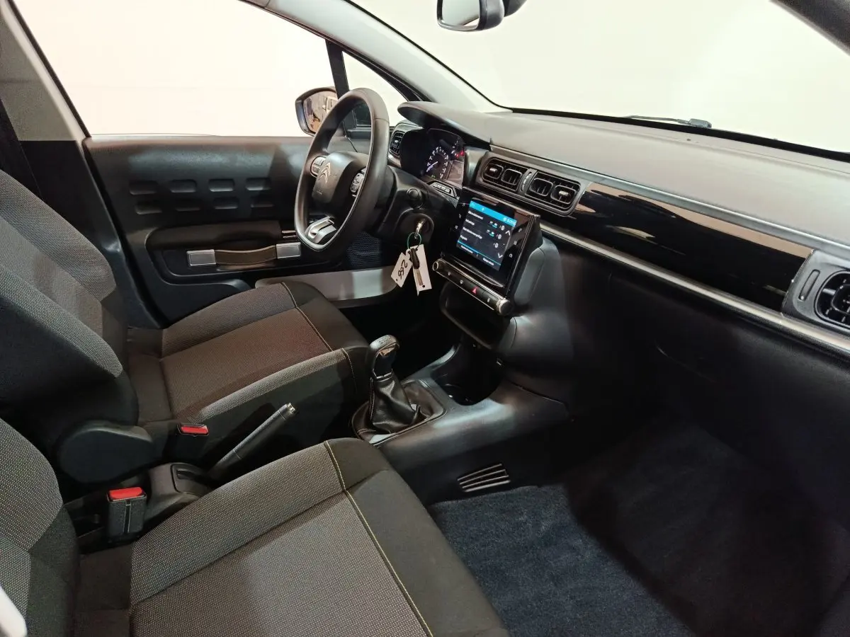 Intérieur de Citroën C3 2020 vue côté conducteur, tableau de bord noir avec écran tactile et volant multifonctions.