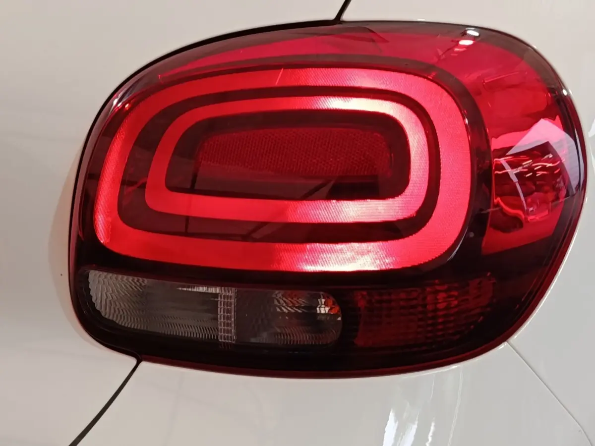 Gros plan sur le feu arrière droit rouge d'une Citroën C3 blanche, version PureTech 83 S&S BVM Feel Business 2020.