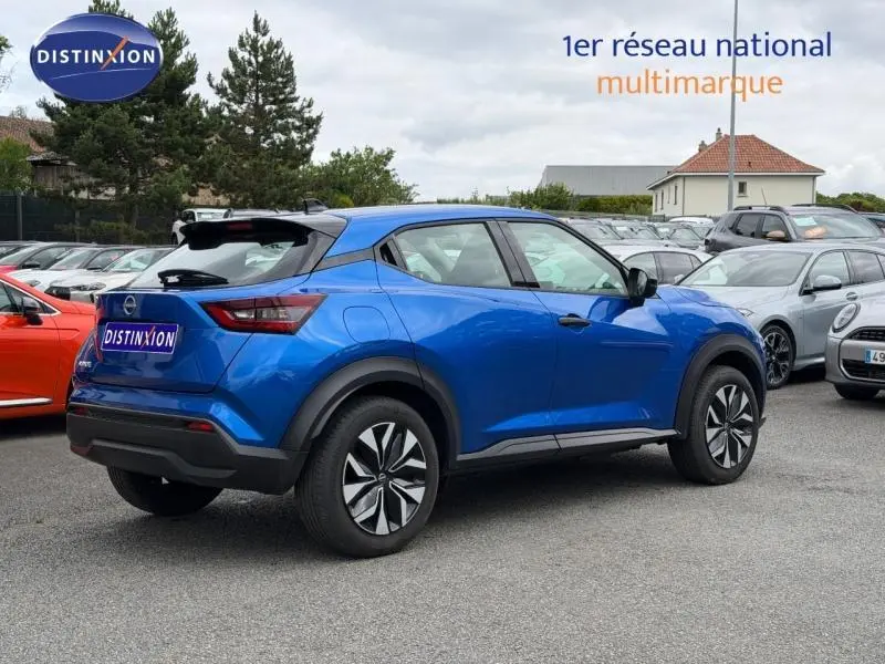 Vue 3/4 arrière droite d'un Nissan Juke 2025 bleu magnétique avec jantes distinctives et toit noir contrasté.
