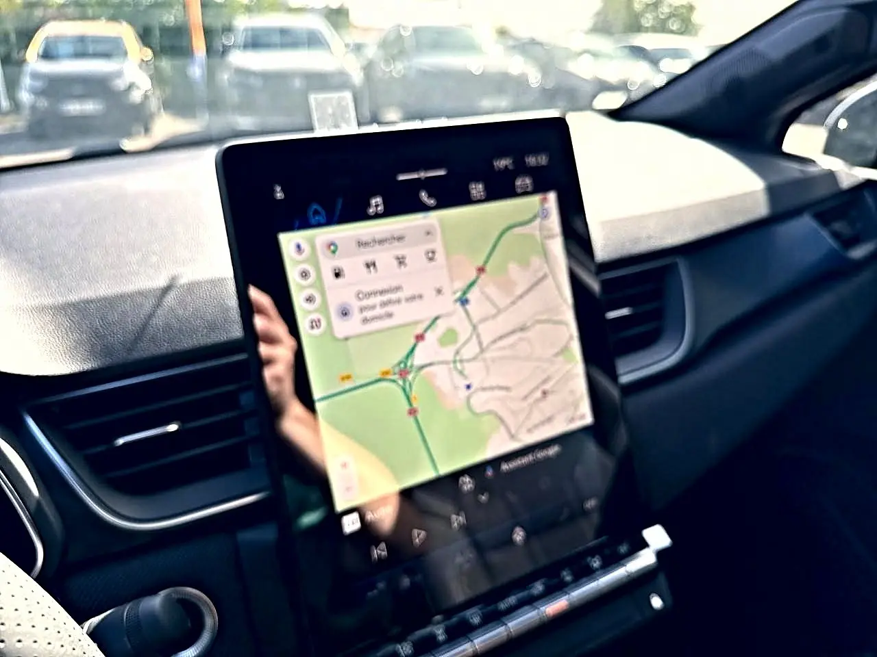 Vue intérieure du tableau de bord de la Renault Symbioz gris rafale, avec écran tactile affichant un GPS cartographique.