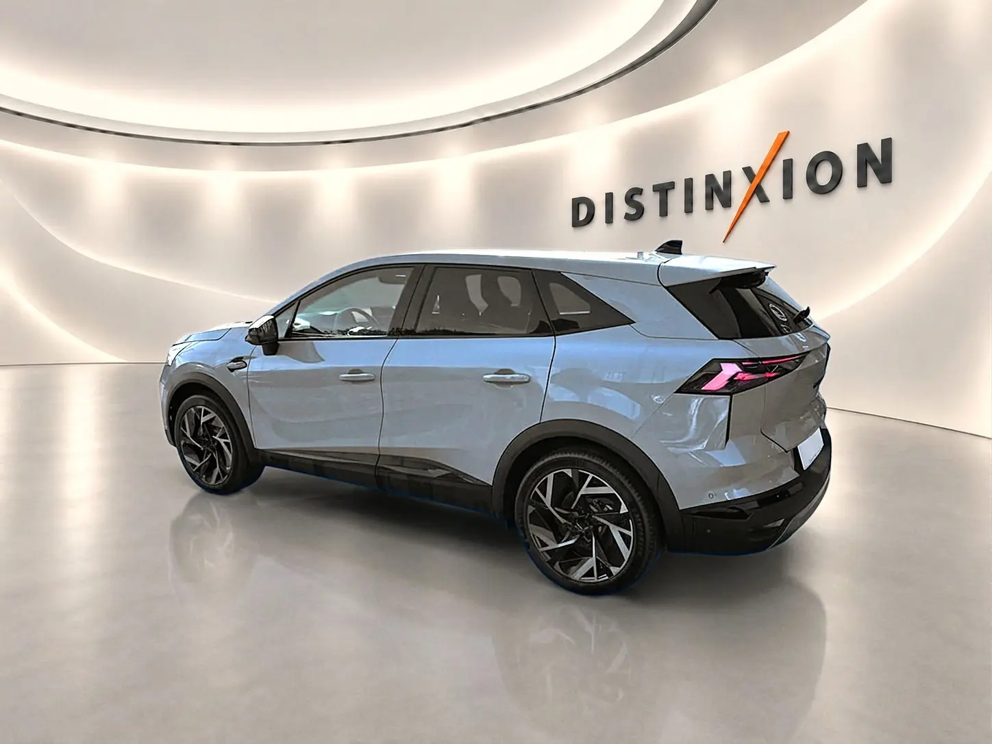 Renault Symbioz gris rafale en vue 3/4 arrière droit, avec jantes alu noires et feux arrière LED distinctifs.