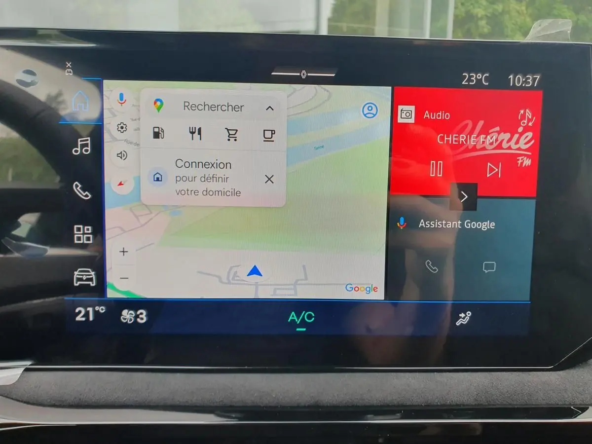 Vue intérieure du tableau de bord de la Renault Clio VI hybride avec écran tactile affichant navigation et radio.