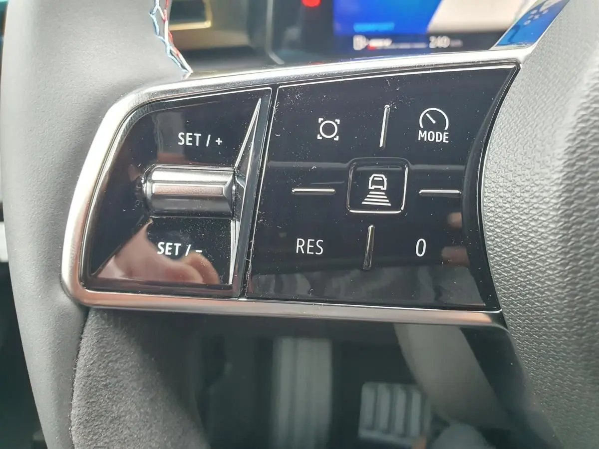 Gros plan sur les commandes de régulateur de vitesse au volant de la Renault Clio VI gris Rafale, finition Esprit Alpine.