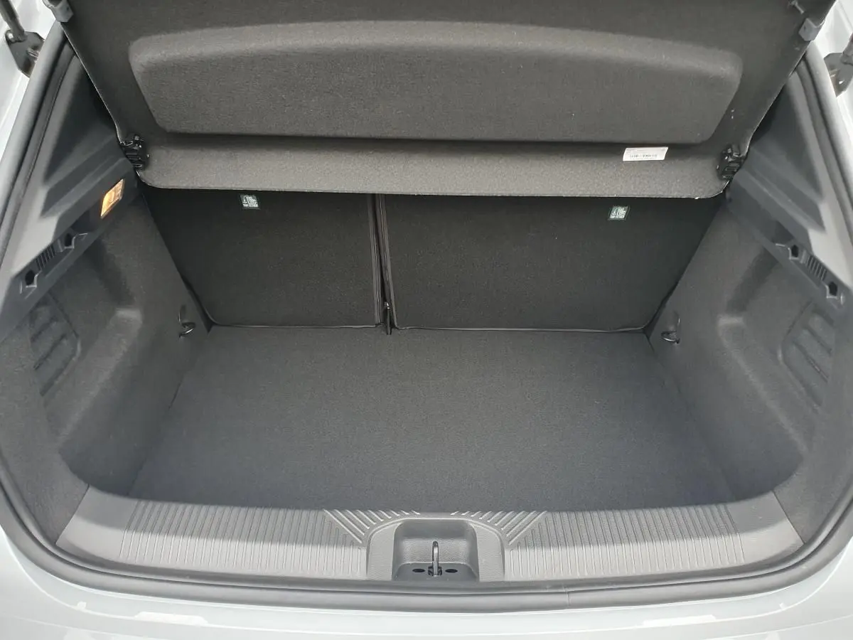 Coffre ouvert vu de l'arrière de la Renault Clio VI gris Rafale, montrant un espace de chargement propre et vide.
