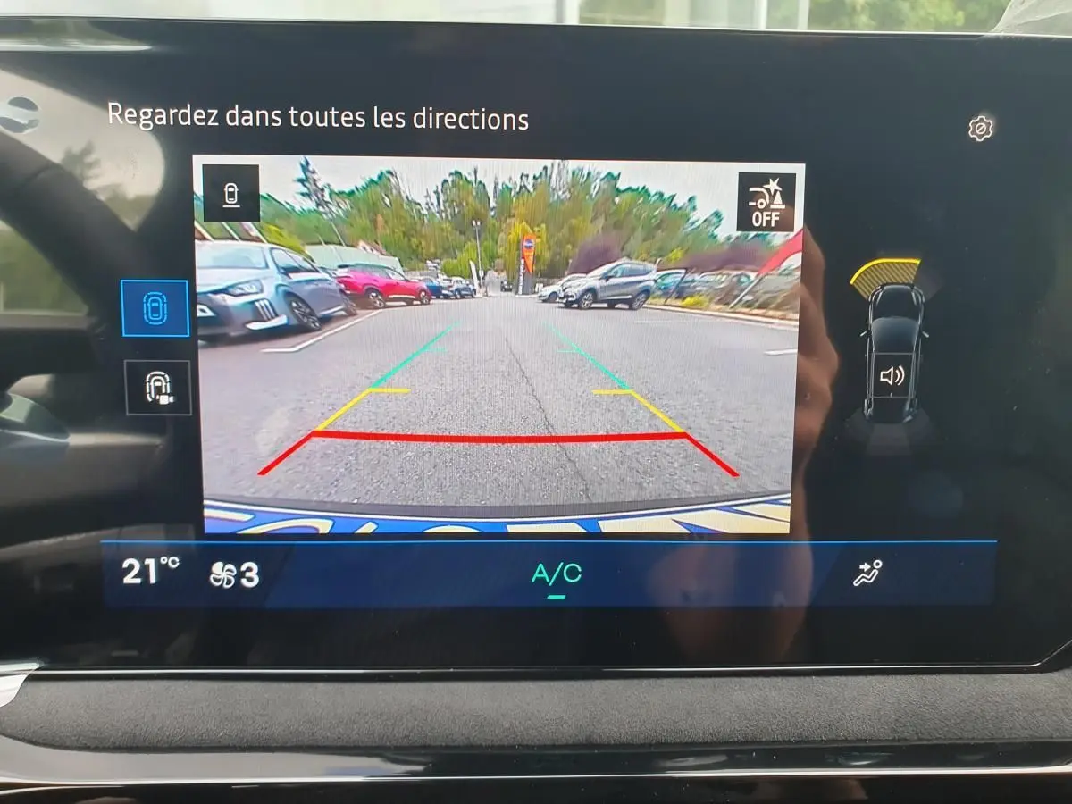 Affichage de la caméra de recul sur l’écran intérieur d’une Renault Clio VI gris Rafale, avec guidage de trajectoire coloré.